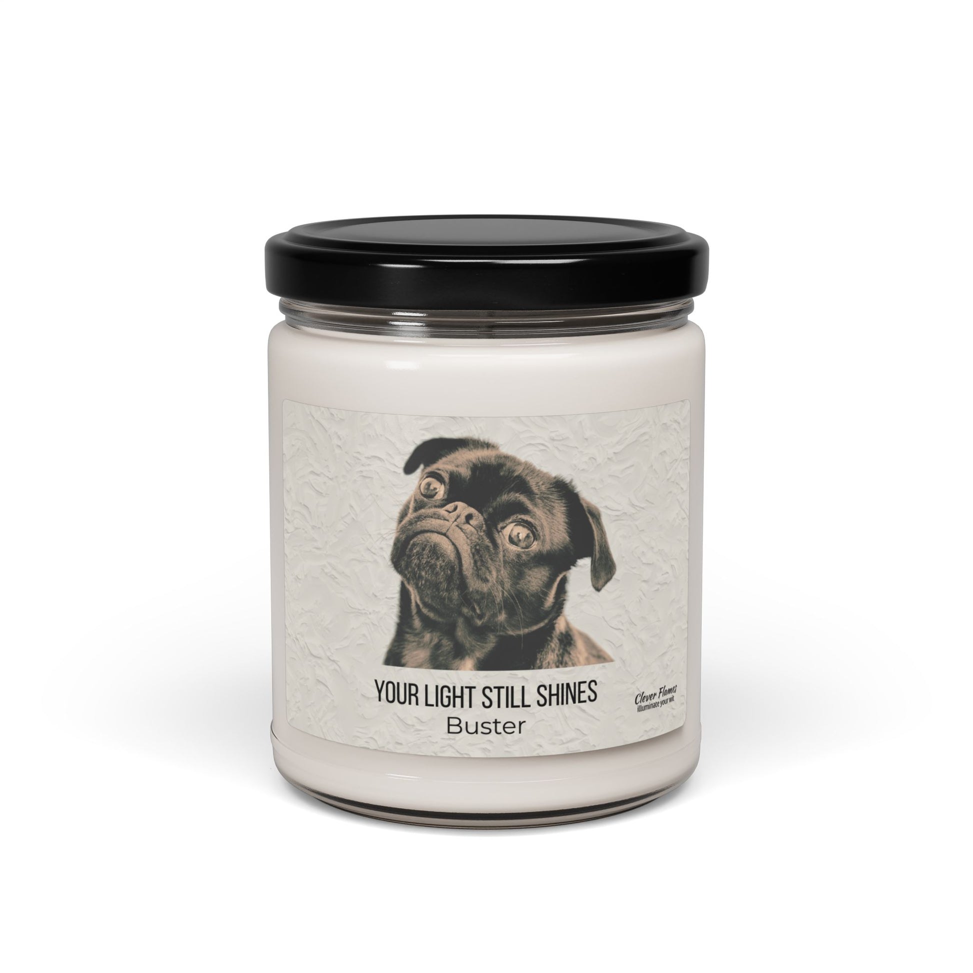 The Your Light Still Shines Personalized Pet Memorial Candle by Printify features a white jar with a black lid and a label with a black pug, the text “YOUR LIGHT STILL SHINES,” and pet’s name. A touching sympathy gift for pet lovers.
