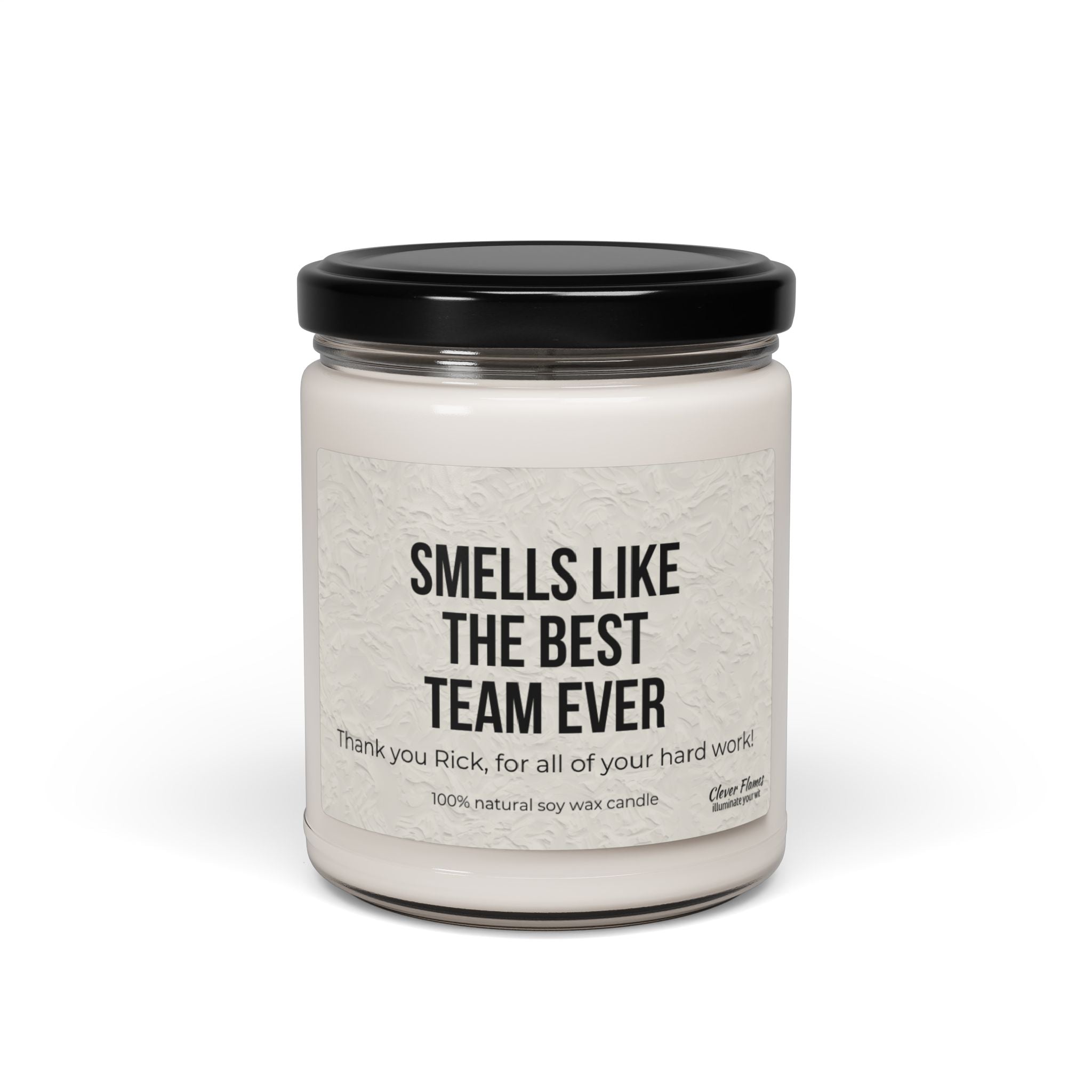 This scented soy candle from Printify comes in a reusable glass jar with a black lid, featuring the label "Smells like the best team ever. Thank you, Rick, for all of your hard work!" It's crafted with 100% natural soy wax, making it an ideal personalized corporate gift or employee Christmas present.