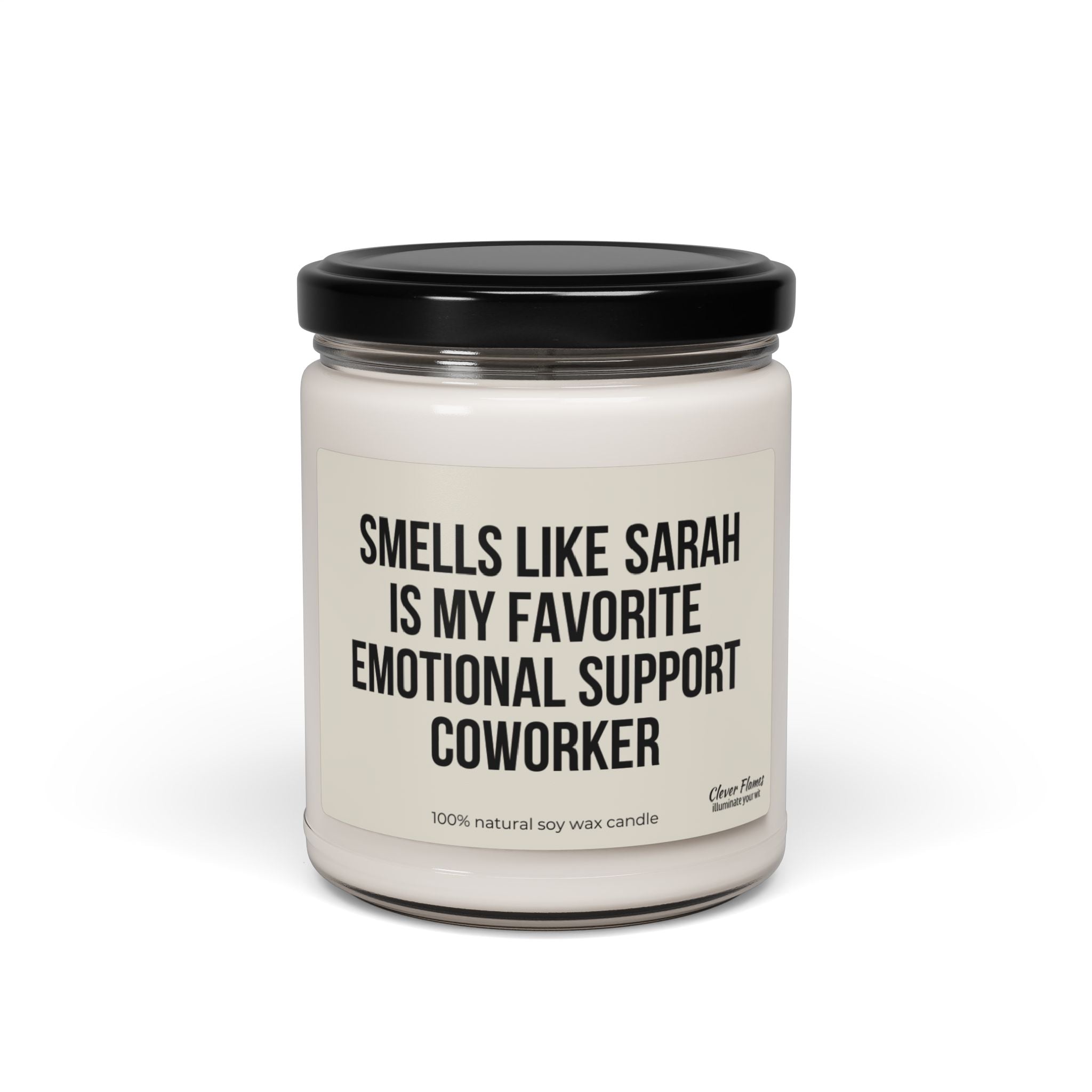 A personalized soy candle from Printify, made with 100% natural and eco-friendly soy wax, comes in a glass jar with a black lid. The label humorously reads "Smells Like Sarah is my favorite emotional support coworker," making it a perfect departing gift for your best friend or work bestie.