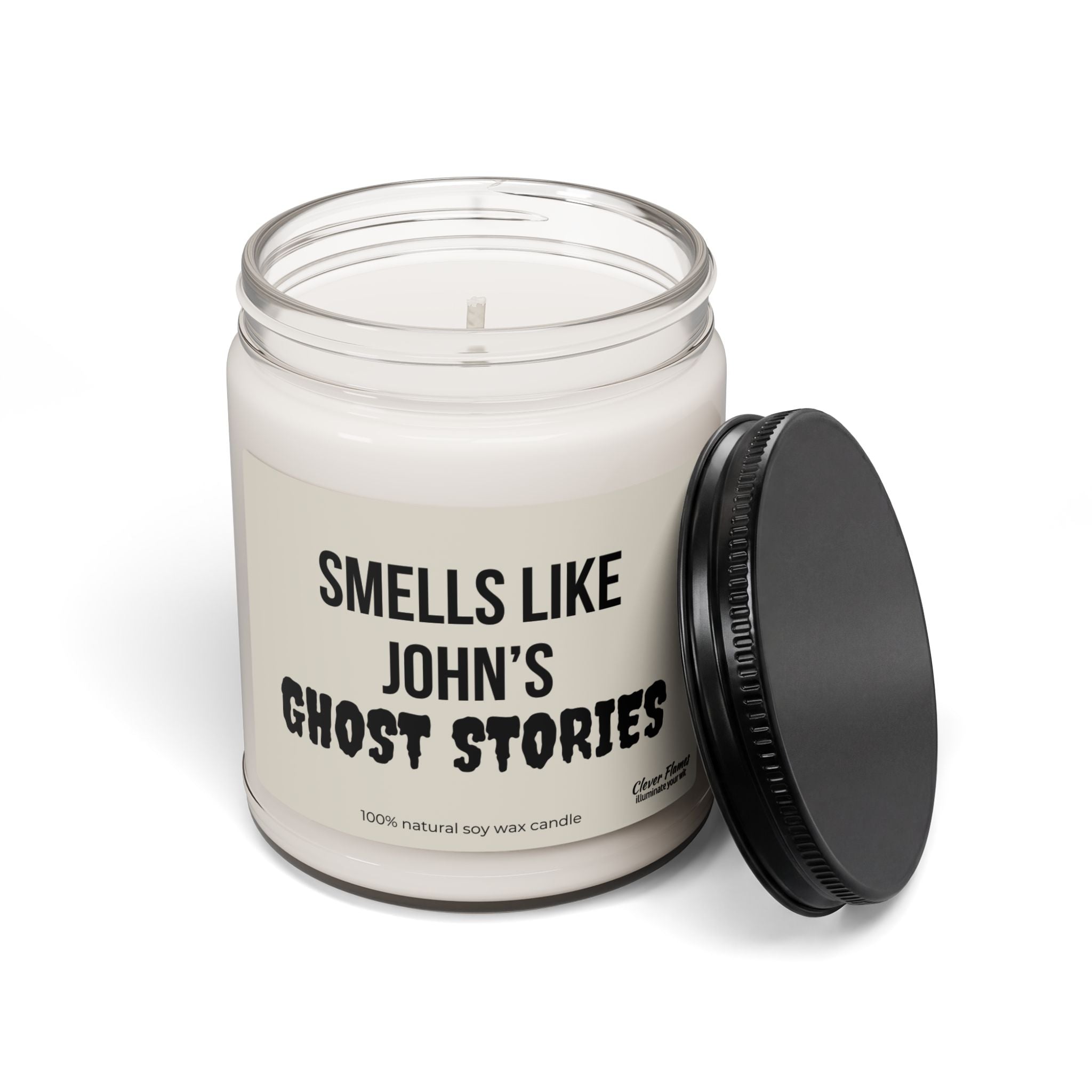 A white soy wax scented candle from Printify, housed in a glass jar with a black lid, is the perfect Personalized Ghost Stories Soy Halloween Candle Gift for adding spooky decor to your fall or October holiday room. The bold label reads “SMELLS LIKE JOHNS GHOST STORIES,” making it an ideal choice for those who love personalized Halloween accents.