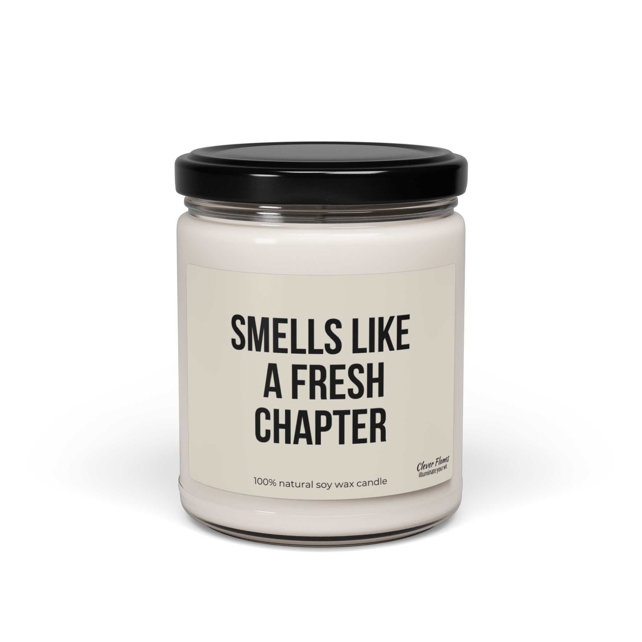 A candle in a glass jar with a black lid features the label "Smells Like a Fresh Chapter" and is perfect for book enthusiasts. Made with 100% natural soy wax, it is an ideal smut reader gift or humorous addition to any book lover's collection. This product, called the Funny Candle For Reader Gift by Printify, makes an excellent bookshelf decor item for romance readers and bookish merch aficionados.