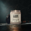 A lit Grandpa Pregnancy Announcement Candle in a glass jar with a personalized label that reads, Its Giving Grandpa, February 2027, Baby Smith.