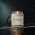 The Printify "Smells Like She's Planning a Trip" 9oz soy candle glows cozily on a dark surface, its travel-themed label visible beside the lid, highlighting this eco-friendly gift's inviting charm.