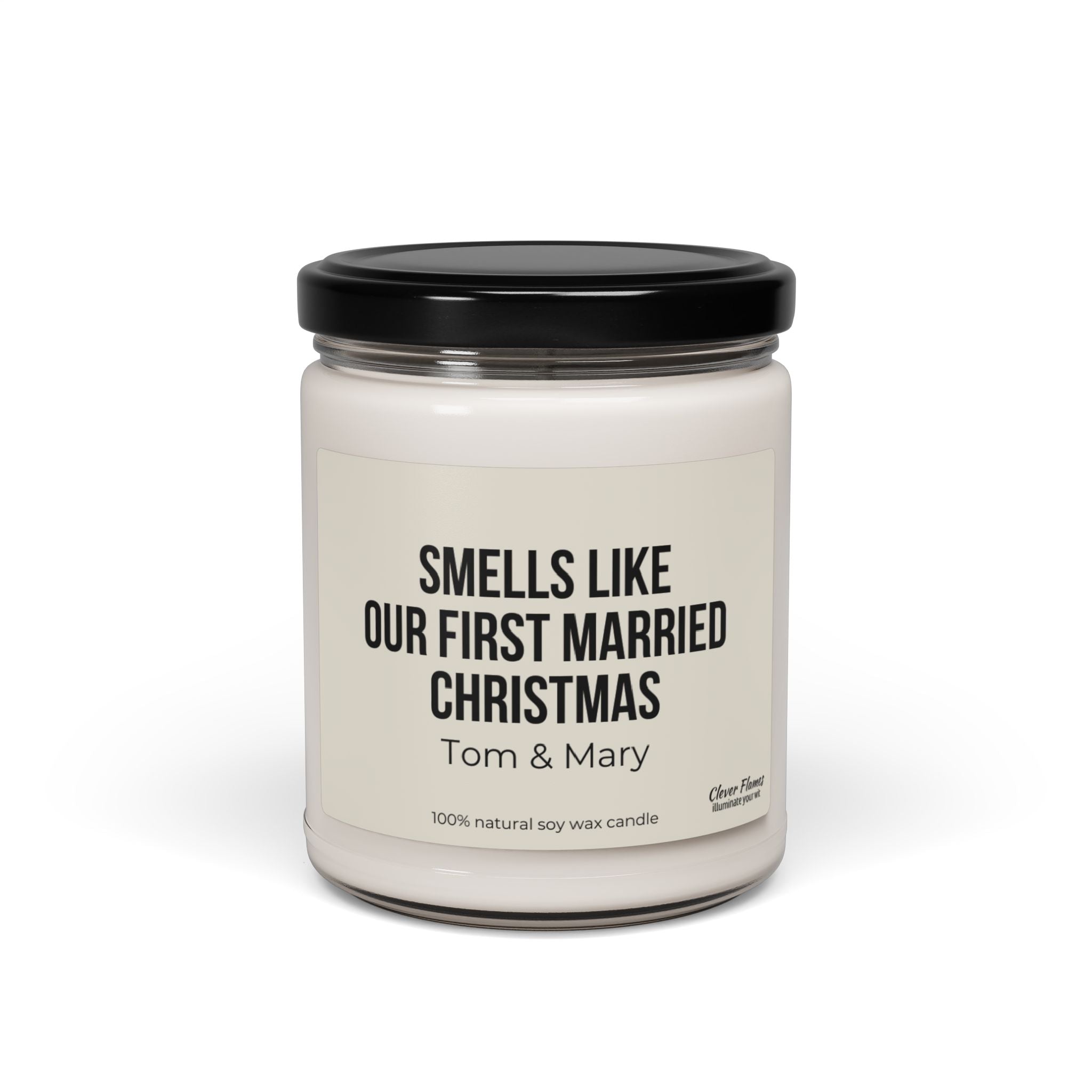 A personalized White Christmas Candle by Printify, featuring a black lid and a touching label that reads "Smells Like Our First Married Christmas, Tom & Mary." Crafted with 100% natural soy wax, this candle in a glass jar makes an ideal gift for newlyweds.