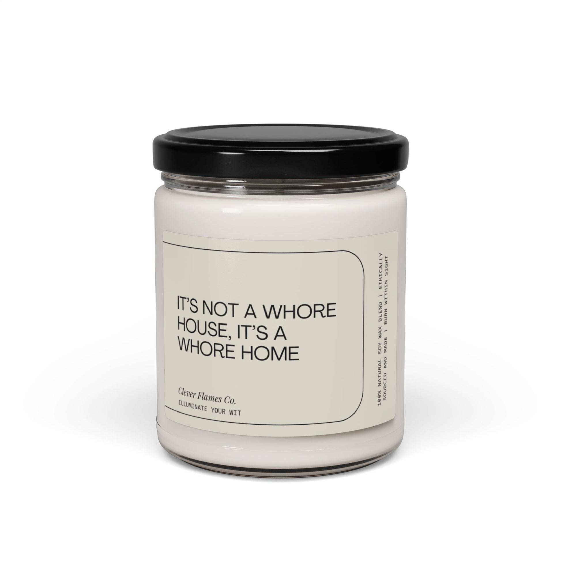 A white candle jar with a black lid showcases a witty label proclaiming, "It's not a whore house; it's a whore home." Made from natural soy wax, this sassy scented candle by Printify delivers bold and irreverent charm to any space, serving as the perfect addition for those seeking fun and inclusive adult decor.
