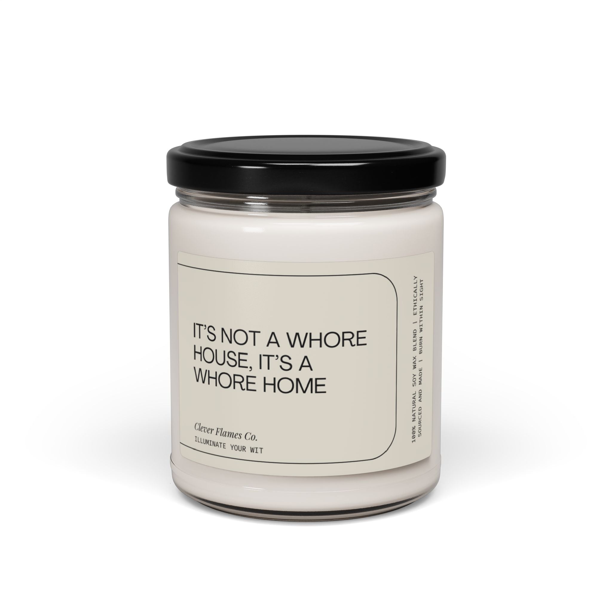 A white candle jar with a black lid showcases a witty label proclaiming, "It's not a whore house; it's a whore home." Made from natural soy wax, this sassy scented candle by Printify delivers bold and irreverent charm to any space, serving as the perfect addition for those seeking fun and inclusive adult decor.