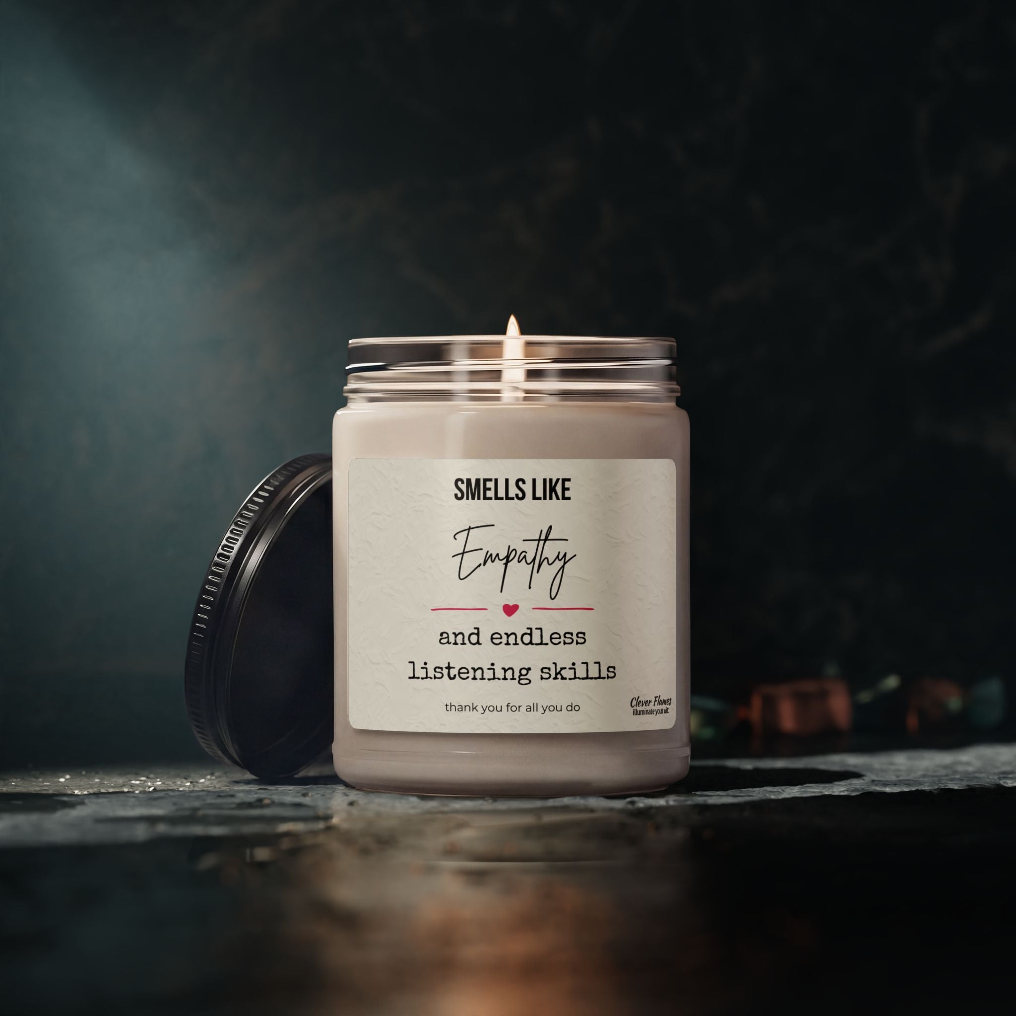 The Printify Empathy Candle – "Smells Like Empathy and Endless Listening Skills" is a 9oz clean-burning soy candle in a glass jar with a black lid, crafted with natural essential oils to say thank you for all you do.