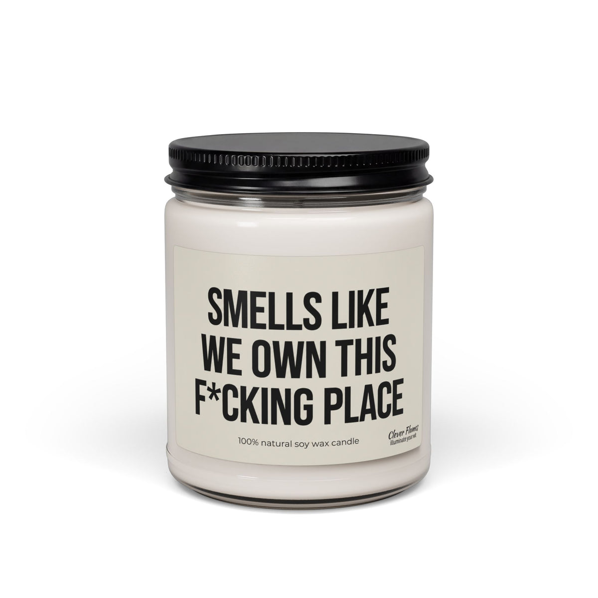 Glass candle jar with a black lid and a label for a Smells Like We Own This F*Cking Place Candle, making it a bold housewarming gift.