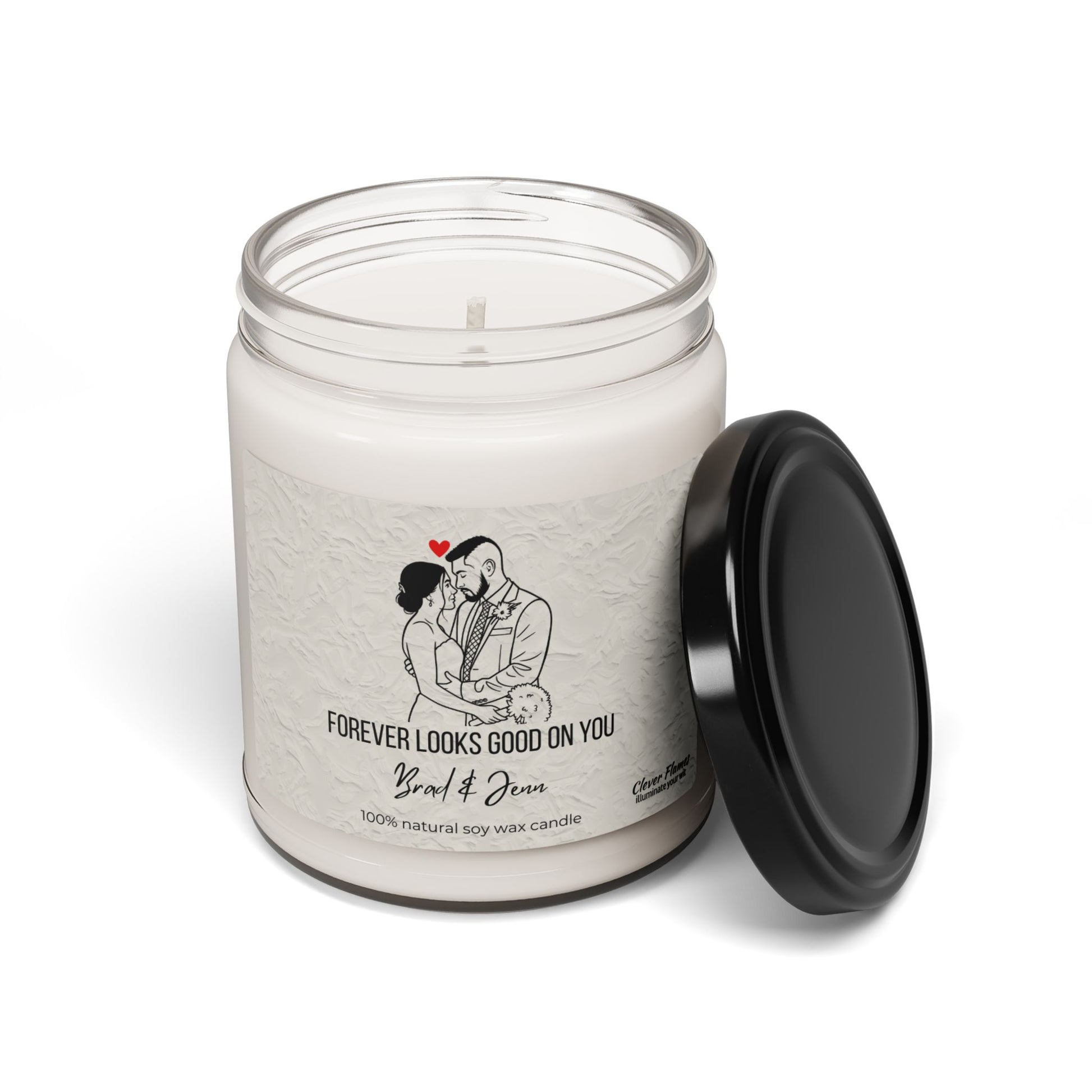 The Printify Custom Couple Candle is a white soy wax candle in a glass jar with black lid, featuring your outlined couple portrait, red heart, and “FOREVER LOOKS GOOD ON YOU – Brad & Jenn”—a perfect personalized wedding or anniversary gift.