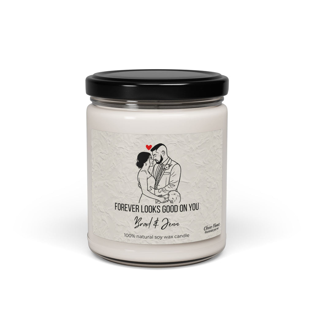A white soy wax candle by Printify in a clear jar with black lid. The label shows custom line art of a couple under a red heart and text: Forever looks good on you, Yard & Oven, 100% natural soy wax candle. Personalizable wedding gift.