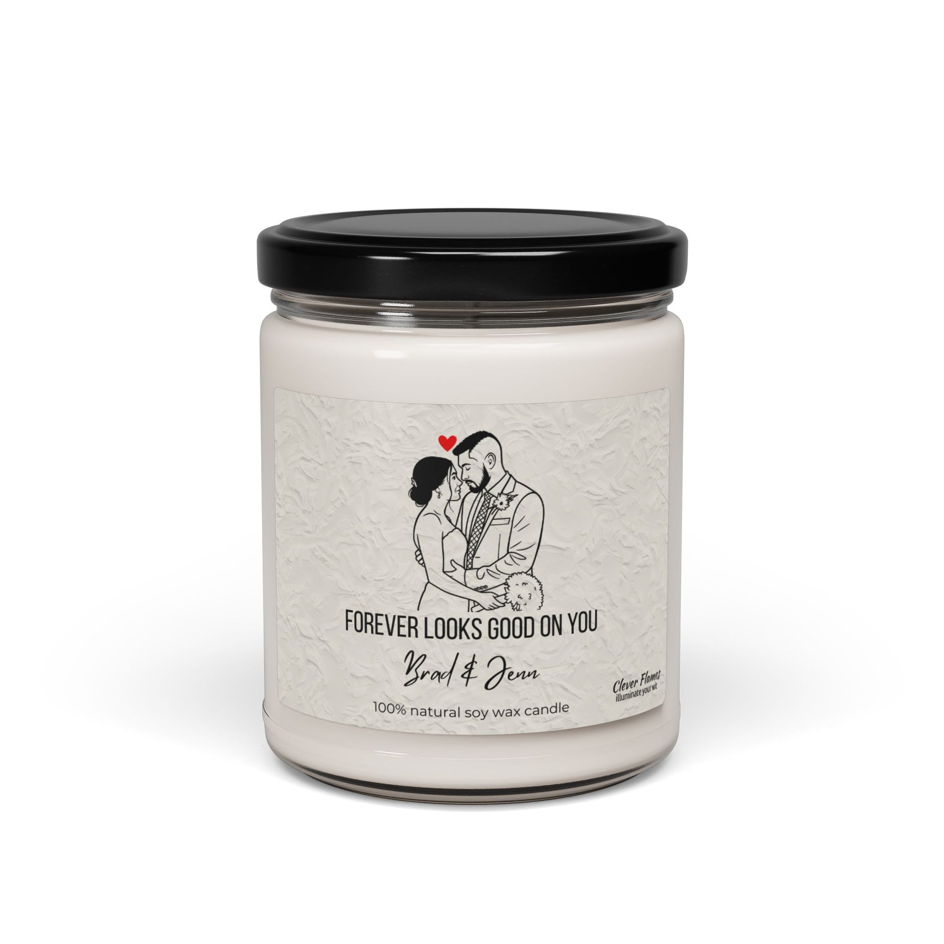A white soy wax candle by Printify in a clear jar with black lid. The label shows custom line art of a couple under a red heart and text: Forever looks good on you, Yard & Oven, 100% natural soy wax candle. Personalizable wedding gift.