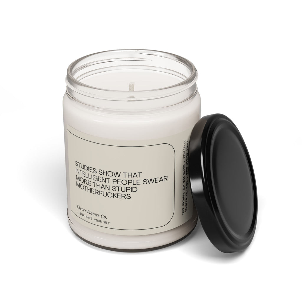 A quirky scented candle from Printify, featuring a humorous label that reads: "Studies Have Shown That Intelligent People Swear More than..." This natural soy candle comes in a clear glass jar with a black lid beside it and makes for the perfect funny gift to add some humor to any space.